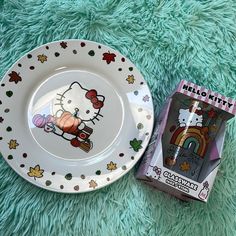 a hello kitty plate and candy box on a green carpet