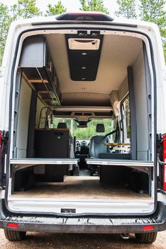 the back end of a white van with its doors open and it's cargo area opened