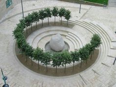 a circular stone structure with trees in the center