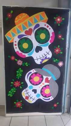 a painting of two skulls with flowers on the front and back of it, one is painted in bright colors