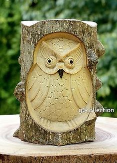 an owl figurine sitting on top of a tree stump