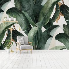 a chair sitting in front of a wall mural with large green leaves on it's sides