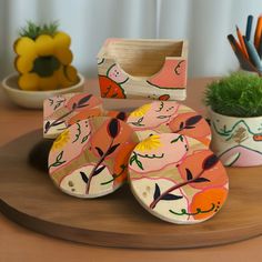 several painted pots and bowls on a wooden table