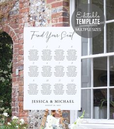 a wedding seating chart is displayed in front of a brick building with white flowers and greenery