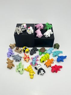 there are many small toy animals in the box on the table and one is black