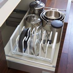 an organized kitchen drawer with pots and pans