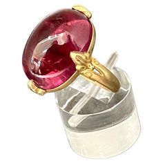 A clear 13 x 18 mm cabochon cut salmon pink tourmaline is held in 4 carved prongs in this Steven Battelle designed 18K gold setting. This allows for lots of light interplay and a lively stone. A tapered matte finish shank currently sized 7 completes. This ring is resizable. exquisite... Luxury Tourmaline Jewelry In Oval Cabochon Shape, Luxury Tourmaline Oval Cabochon Jewelry, Luxury Tourmaline Jewelry With Oval Cabochon, Elegant Round Ruby Intaglio Ring, Elegant Round Ruby Ring With Intaglio Detail, Elegant Oval Ruby Ring With Intaglio, Pink Spinel, Pink Tourmaline Ring, Fancy Rings