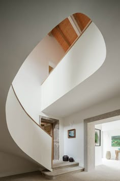 the interior of a modern house with white walls and stairs leading up to an open floor plan