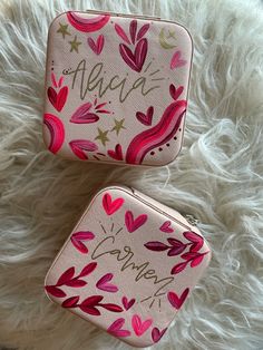 two small purses sitting on top of a white furnishce covered floor next to each other