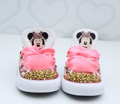 a pair of minnie mouse shoes with pink bows and gold sequins on them