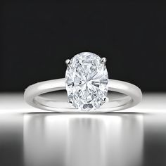 an oval cut diamond ring on a reflective surface, with the center setting in white gold