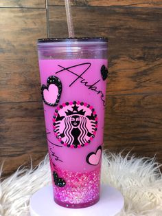 a pink starbucks cup sitting on top of a white plate