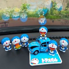 a group of cartoon figurines sitting on the dashboard of a car in front of a window