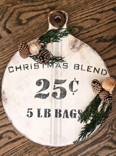 a wooden sign that says christmas blend with pine cones on it