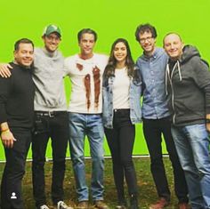 a group of people standing next to each other in front of a green screen