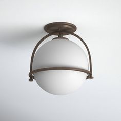 an overhead light fixture with a white glass ball on the top and brown metal frame