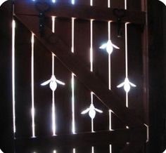 an open barn door with lights on the side and behind it is a wooden fence