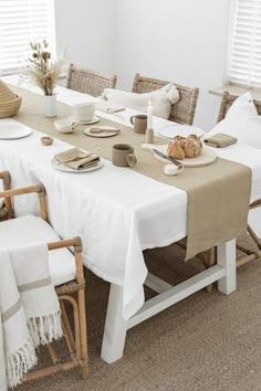 a dining room table set with place settings