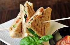 a sandwich cut in half on a plate with toothpicks sticking out of it