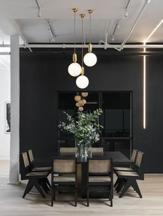 a dining room table with chairs and a vase filled with flowers