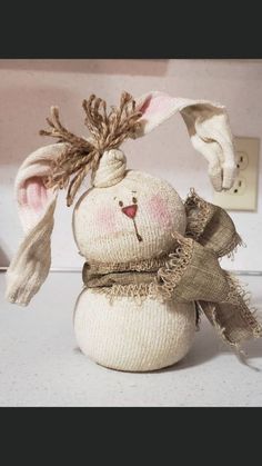 a stuffed rabbit is sitting on the counter top with its head turned to look like it's wearing a scarf