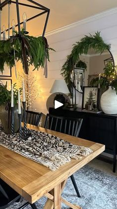 a wooden table with black chairs and green plants