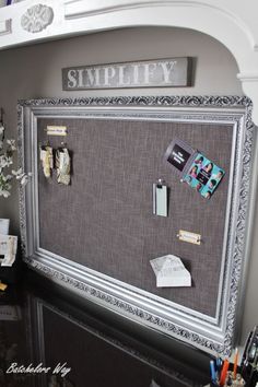 a bulletin board that is on the wall with some papers and magnets attached to it