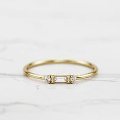 a gold ring with two diamonds on it