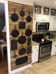 a kitchen with pots and pans hanging on the wall next to stove top oven