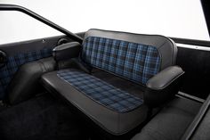 the interior of a vehicle with blue and black plaid upholstered seats