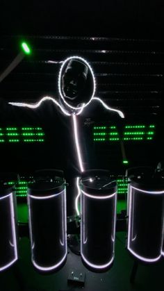 a man with glowing arms and legs standing in front of three trash cans