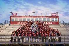 the team is posing for a photo in front of bleachers