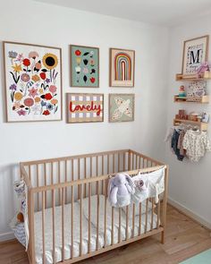 a baby's room with pictures on the wall and toys in the crib