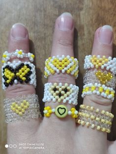 four different rings made to look like beaded bracelets on someone's hand