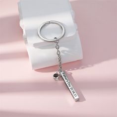 a keychain with a name on it sitting next to a white napkin and pink background