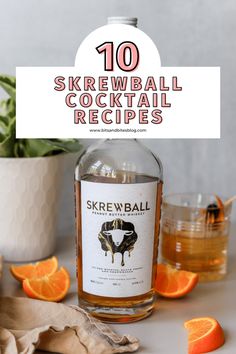 a bottle of skrewball cocktail next to sliced oranges and a potted plant