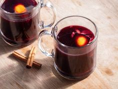 two mugs filled with liquid and cinnamon sticks