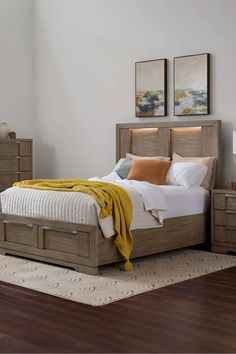 a bed sitting on top of a wooden floor next to a dresser and mirror in a bedroom