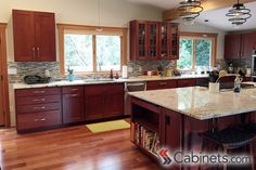 a large kitchen with wooden floors and lots of counter space, including an island in the middle