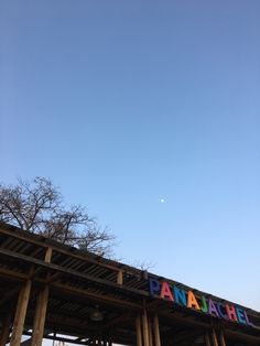 a sign that reads panache on the side of a wooden structure under a blue sky