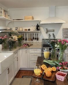 a kitchen filled with lots of white cabinets and counter top next to a wooden table