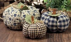 three decorative pumpkins sitting on top of a wooden table