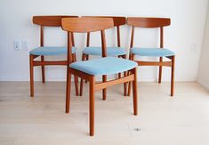 three wooden chairs sitting next to each other on top of a hard wood floored floor