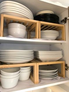 plates and bowls are stacked on wooden shelves