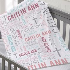 a baby crib with a blanket that has the names of different people on it