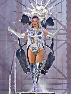 a woman in a silver bodysuit on stage