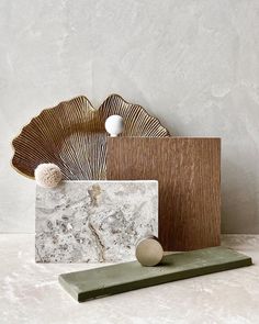 marble and wood are on display in front of a white wall