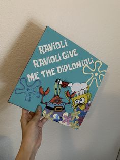 someone is holding up a book that says ravioli ravoli give me the diploma