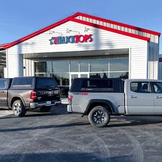 two trucks are parked in front of a store