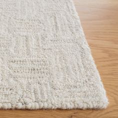 a white rug on top of a wooden floor